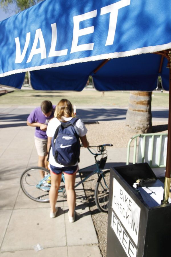 TJ Dalton(in purple) assists a customer as a bike valet across from the Student Union Memorial Center on Monday 19 Sept 2011.  The bike valets are there from 9 a.m. to 6 p.m and will watch your bike for free. 

Keith Hickman-Perfetti / Arizona Daily Wildcat
