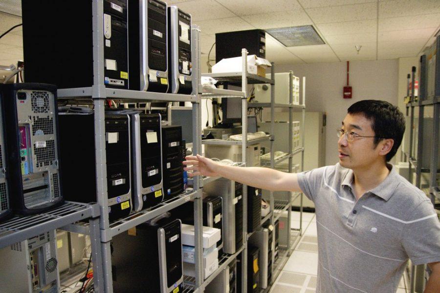 Gordon Bates / Arizona Daily Wildcat
U of A Computer Science Departments Biechuan Zhang shows the network hardware that he and four UA students are using for a recent internet technology project, Green Net. The project is developing a way for network servers to reduce the amount of work that they do by monitoring user traffic, and adjusting the activity of the server accordingly.