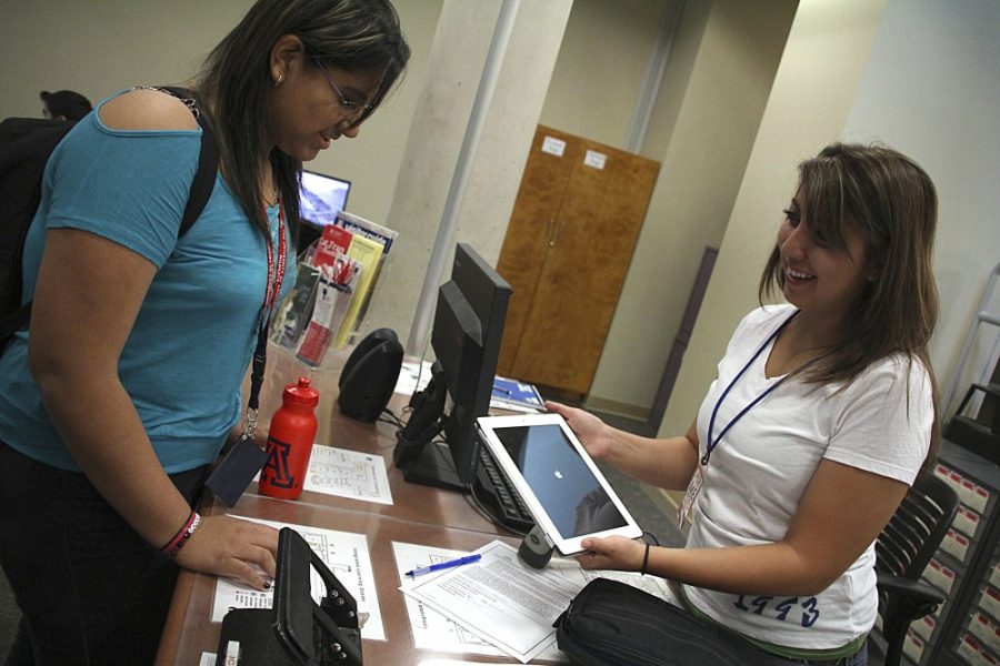 Kevin Brost / Arizona Daily Wildcat
Valeria Monteros rents an iPad 2 from employee Monique Perez at the Integrated Learning Center Information Commons desk on September 14th, 2011.
