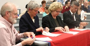 From left to right, Vice Chair of the Faculty Robert Mitchell, Provost Meredith Hay, Chair of the Faculty Wanda Howell and UA President Robert Shelton review and sign a shared governance document dividing power between the faculty and the Office of the President during the Faculty Senate meeting held Monday in the James E. Rogers College of Law.