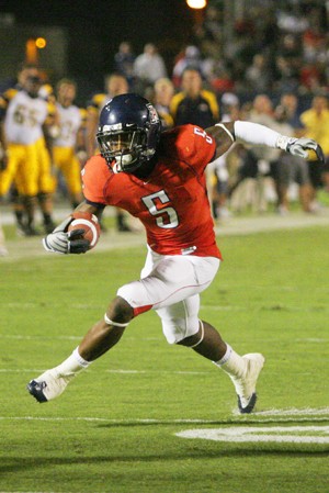 Wildcat running back Nic Grigsby darts up field during Arizonas 41-16 victory over Toledo at Arizona Stadium Saturday night. Grigsby amassed 135 yards and three touchdowns on 20 carries, his second straight game rushing for multiple scores and at least 100 yards. 