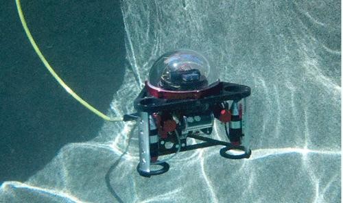 The Autonomous Cooperative Underwater Robotic Vehicle, or A-CURV, takes a test dive in a swimming pool. Eduardo Moreno?s new brand of robot will be low-cost and could conceivably administer underwater services to the Navy, film crews, the Department of Homeland Security and rescue missions.