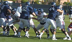 Arizonas offensive line, Bill Wacholz (52), Jon Longacre (75) and Peter Graniello (76), duke it out in practice against the UAs defensive linemen. The embattled group of O-linemen has a new offense, which may help them forget the nightmares of last season.