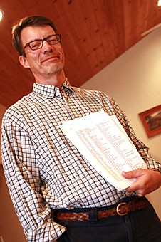 Fenton Johnson, an associate professor of English, holds a petition against Proposition 107 at his home yesterday evening. Johnson and the signers of the document are working to defeat the controversial proposition, which would require government programs to end domestic-partnership benefits.