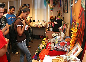 Pre-pharmacy freshman Kellie Vasquez looks at a student-made altar during a Day of the Dead celebration in the CǸsar E. Chǭvez building yesterday afternoon.