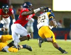 UA linebacker Sterling Lewis latches onto Toledo running back DeJuane Collins in the Wildcats 41-16 win over the Rockets Saturday night at Arizona Stadium. Lewis had a team-high 12 tackles as he filled in for an injured Xavier Kelley.