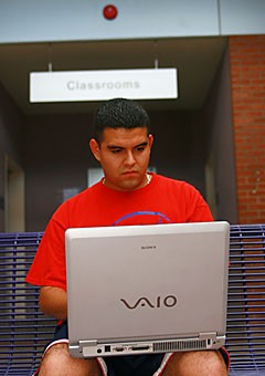 Sergio Valencia, a junior majoring in business management and Spanish, downloads practice sheets for a class using the UA WiFi network yesterday in the Manuel T. Pacheco Integrated Learning Center. The campuswide wireless network was funded in part by a $50 technology fee added to tuition.