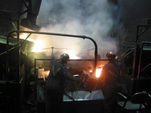 Workers tend to a furnace at Revere Copper in Rochester, New York, that melts scrap copper into a liquid that cools into large copper cakes, which in turn are flattened with machinery into thins coils for use in a variety of electrical products, on October 20, 2010. (Kevin G. Hall/MCT)