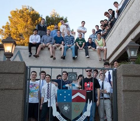 Members of the fraternity Delta Tau Delta stand proud in front of their newly renewed charter, Monday. Sophomore President Jack Donohue is very excited about the changes the fraternity has made.