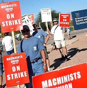 Raytheon employee Hernand Enriquez strikes with Len Martel, center, and Steve Horchair, right, outside the Raytheon complex yesterday. The machinists at Raytheon are on strike to receive increased wages.