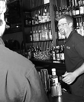 Music education graduate student Tyler Dunn bartends at the newly opened Auld Dubliner yesterday evening. Some say that the University Boulevard location is cursed, citing numerous failed businesses previously located there.