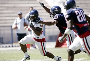 UA defensive back Corey Hall (21) gets a hand on receiver Mike Thomas as he heads to the end zone in the Wildcats Spring Game in Arizona Stadium on Saturday. Thomas had three catches for 42 yards and a touchdown and Hall intercepted a Willie Tuitama pass in the game.