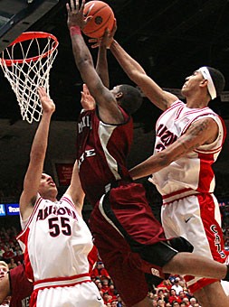 Arizona forward Marcus Williams gets a hand on a shot attempt from New Mexico State guard Justin Hawkins in yesterdays 102-87 Arizona victory in McKale Center. Williams played 39 minutes for an Arizona squad that used its bench for just 13 minutes, as no starter played less than 36 minutes.