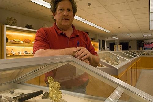 Mark Cande, an assistant curator at the Flandrau Science Center, talks about one of the pieces that will be sold at the Gem and Mineral show. The gold was part of the 1992 Christmas gold discovery.
