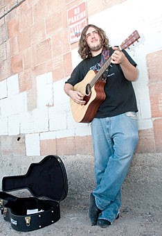 Jeremy Williams plays outside of The Rialto Theatre yesterday afternoon. His band ,Crossing Sarnoff ,will be playing Friday night at The Hut.