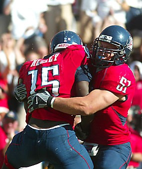 UA linebacker Spencer Larsen bear hugs his 