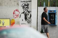 Bryan Fraunfelter, a psychology freshman, passes by several pieces of graffiti art on a wall along Sixth Street near Park Avenue. 