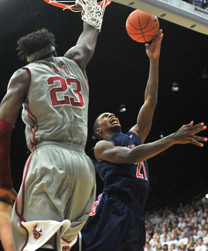 Arizona guard Kyle Fogg, right, shoots a left-handed floater over Washington State big man DeAngelo Casto, left, in Arizona?s loss to the Cougars in Pullman, Wash., Saturday. The Wildcats now feel fortunate to play five of their final seven games in McKale Center. 
