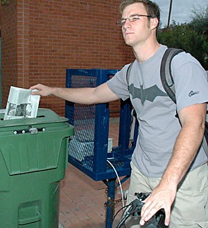 Mark Jankauski, an undeclared freshman, recycles his newspaper. Campuses across the nation, including Arizona State University and  Northern Arizona University, recently signed an environmental pact to create climate-neutral campuses; however, the UA did not sign it.