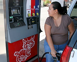 Denise Romero fills her gas tank at Jetts Wildcat on North Park Avenue and East Sixth Street. Romero and her family have been financially affected by this summers high gas prices. 