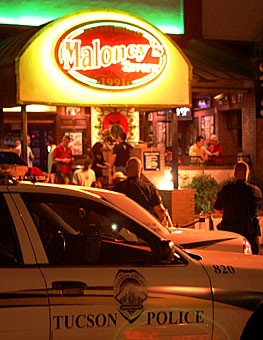 Tucson Police Department officers wait outside Maloneys Tavern Saturday evening. Extra police officers were deployed for the Labor Day weekend, resulting in more than 60 DUIs being issued between Friday and Saturday alone.