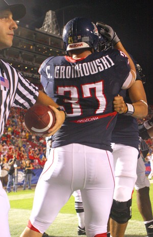 Chris Gronkowski celebrates with a teammate and his brother, Rob, hauls in a pass in last years game against Washington State. While both brothers have their own identity within the Arizona football team, the two lean on each other during the football season. 
