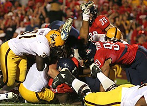 Arizona and ASU football players get tangled up during last years 28-14 Sun Devil victory at Arizona Stadium. The rivals will play for the Territorial Cup tomorrow at 6 p.m. at Sun Devil Stadium in a game with much on the line for both teams.