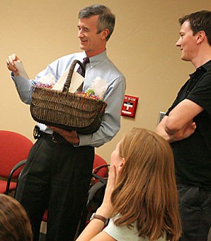 President Robert Shelton, left, smiles as he accepts a basket containing margarita mix and other gifts from Graduate and Professional Student Council President Paul Thorn, a philosophy graduate student, and other members of the GPSC. They met last night in the Student Union Memorial Center to discuss matters important to the UA graduate student community.