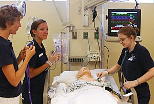 Fifth-semester traditional-nursing students Ashley Taylor, Cara Drinousky and Nicole Marble demonstrate the new training facility where nursing students will use dummies to learn how to treat and care for patients . The College of Nursing celebrated its 50th anniversary with the opening of the Steele Innovative Learning Center yesterday afternoon. 