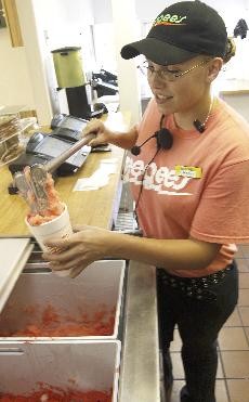 Christina Lauvly, 19, scoops a watermelon Eegee slushy for a customer at the Eegees at the northeast Campbell Avenue and Grant Road.