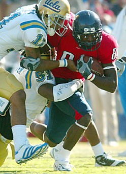 Arizona wide receiver Terrell Turner tries to escape the hold of Bruins Dennis Keyes (11) and Reggie Carter (51) in the Wildcats 34-27 win over UCLA at Arizona Stadium on Nov. 3.
