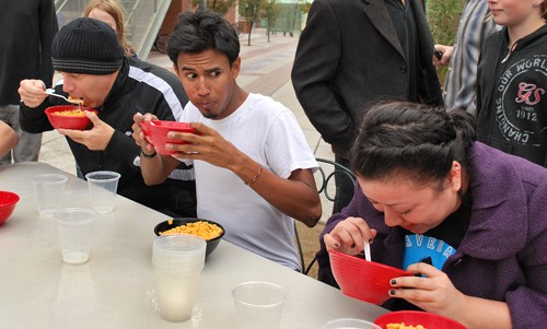 Valentina Martinelli/ Arizona Daily Wildcat

Chris Philips, left, a real estate investor from Oro Valley, focuses on eating two bowels of cereal while Rubin Navarrete, a senior majoring in Spanish, worriedly looks at Tucson resident Revai Hernandez, 25, after she announced difficulty keeping down her second bowl of cereal. The Cereal Boxx hosted an annual cereal-eating contest behind their restaurant on Park Avenue on National Cereal Day Sunday.
