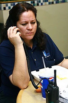 Blanca Estil of the Student Union Memorial Centers Operation Services takes a radio call during her break yesterday evening in the SUMC food court. ProjectConverse, a volunteer program that offers English-speaking classes to UA employees, may soon open to Facilities Management so workers like Estil can brush up on their speaking skills.