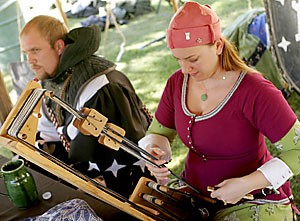 UA alumna Megan Stivler creates narrow-weave trim on a tablet weaver Sunday during the Dragon's Horde event held at Himmel Park. The use of tablet weaving dates from the Viking era to the 17th century. The fantasy-armored tournament was held by the local chapter of the Society for Creative Anachronism. 