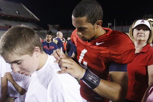Alan Walsh / Arizona Daily Wildcat

Arizona quarterback Nick Foles signs a t-shirt for 15 year old fan Eric Huelsman.