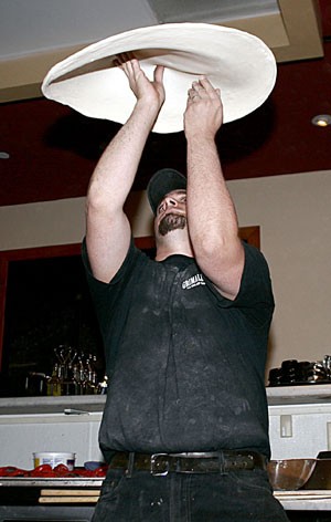 Jamie Culliton shows off his pizza tossing skills at Grimaldis Coal Brick-Oven Pizzeria. 