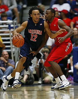 UA guard Daniel Dillon (12) dribbles against fellow guard Jawann McClellan during the Blue teams 76-63 win in the Red-Blue Game on Tuesday in McKale Center. 