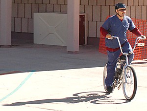 Cosme Rodriguez, 37, rides his motorized bike away from town hall last Tuesday after the city council meeting where he spoke in opposition of motor bike restrictions.  Rodriguez uses the bike as transportation to and from his work.