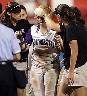 Northwesterns Tammy Williams, center, is helped off the field after an injury sliding into third base in the seventh inning against Arizona in the first game of the 2006 NCAA Division I softball championship in Oklahoma City yesterday. Arizona beat Northwestern 8-0, and will play the team again in game 2 of the series. 