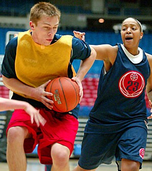 Brian Halbach, a player on the UA womens basketball teams mens practice squad, drives the lane on forward Rhaya Neabors Monday during practice in McKale Center. The NCAA is considering banning the use of mens practice squad for womens teams, a move UA head coach Joan Bonvicini strongly opposes.