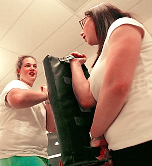 Psychology junior Rebecca Gerrick (left) works on self defense techniques with communication sophomore Serena Lewis during a self defense class at the Alpha Epsilon Phi sorority house. (Photo by Chris Coduto/Arizona Daily Wildcat)