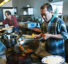 Tony Wong, a 4-year chef at Guilin Chinese Restaurant on East Speedway Boulevard, prepares a dish of General Tsos Chicken.