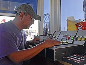 Ray Cammack Shows employee Felix Bishop checks the controls to the Mega Drop ride yesterday afternoon. Spring Fling workers were busy setting up for Spring Fling, which begins today at 4 p.m.