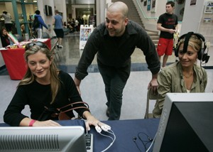 Anthony Rotella of Mind Works Studio explains the use of neurofeedback software to sisters Daria, left, and Kristin Wisneski at the Stress Busters event at the UA Recreation Center on Nov. 13. 