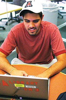First-year pharmacy graduate student Sarjit Patel takes advantage of the librarys free Laptop Loan program. The library is expanding the number of available computers this year in response to the programs popularity.