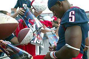 Arizona cornerback Antoine Cason signs autographs for fans in the stands at Saturdays annual Meet the Team session. Arizona Athletics estimated 7,500 fans attended the free event, which was followed by the fall scrimmage.