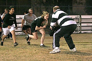 Arizona womens club rugby players, freshman Tina Velasquez, left, junior Amanda Quiles and freshman Jennifer Janes work with assistant coach Rusty Wortman, right, at practice yesterday at Rincon Vista Complex. Most of the women on the team had never played rugby prior to college and came from sports like soccer and softball.