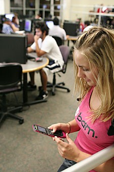 Undeclared freshman Brittany Newell text messages a friend while waiting for a computer in the ILC Tuesday morning.