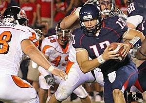 Senior quarterback Kris Heavner tries to get away from Oregon States pass rush during Arizonas 17-10 loss to the Beavers Saturday at Arizona Stadium. Heavner was unsuccessful, as OSUs Curtis Coker dragged him to the ground for one of three Beaver sacks. 