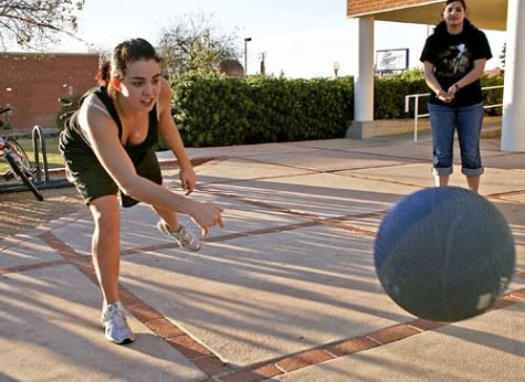 Jordan Waikem, a freshman majoring in theater arts, whacks a kickball into her opponent's zone while pre-business sophomore Rachel Dajches waits for the match to come her way during a game of four square that residents of the Manzanita-Mohave Residence Hall started beside their building yesterday afternoon.